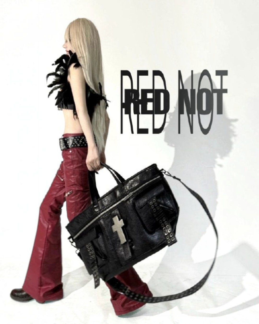 Black studded cross-rupture bag with side pocket, buckled strap, and zip top