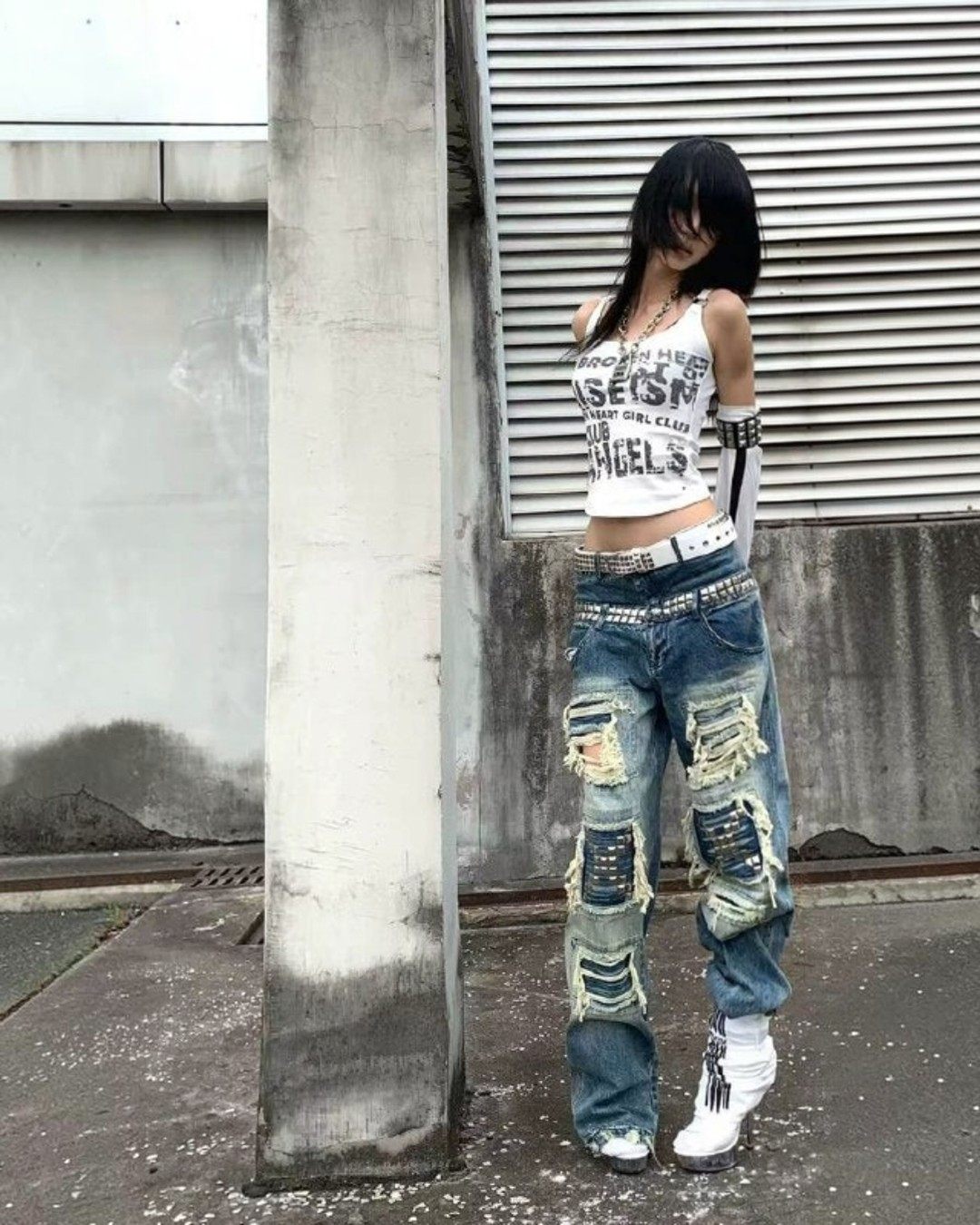 Blue punk jeans with wide legs, patchwork rips, and stitched panels; belt loops