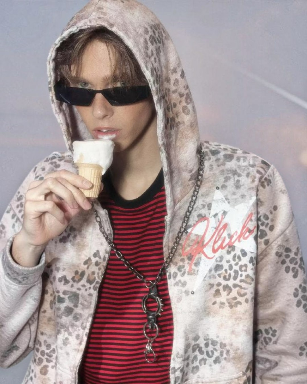 Leopard-print hoodie with hood and Klick logo on chest, worn over a striped shirt
