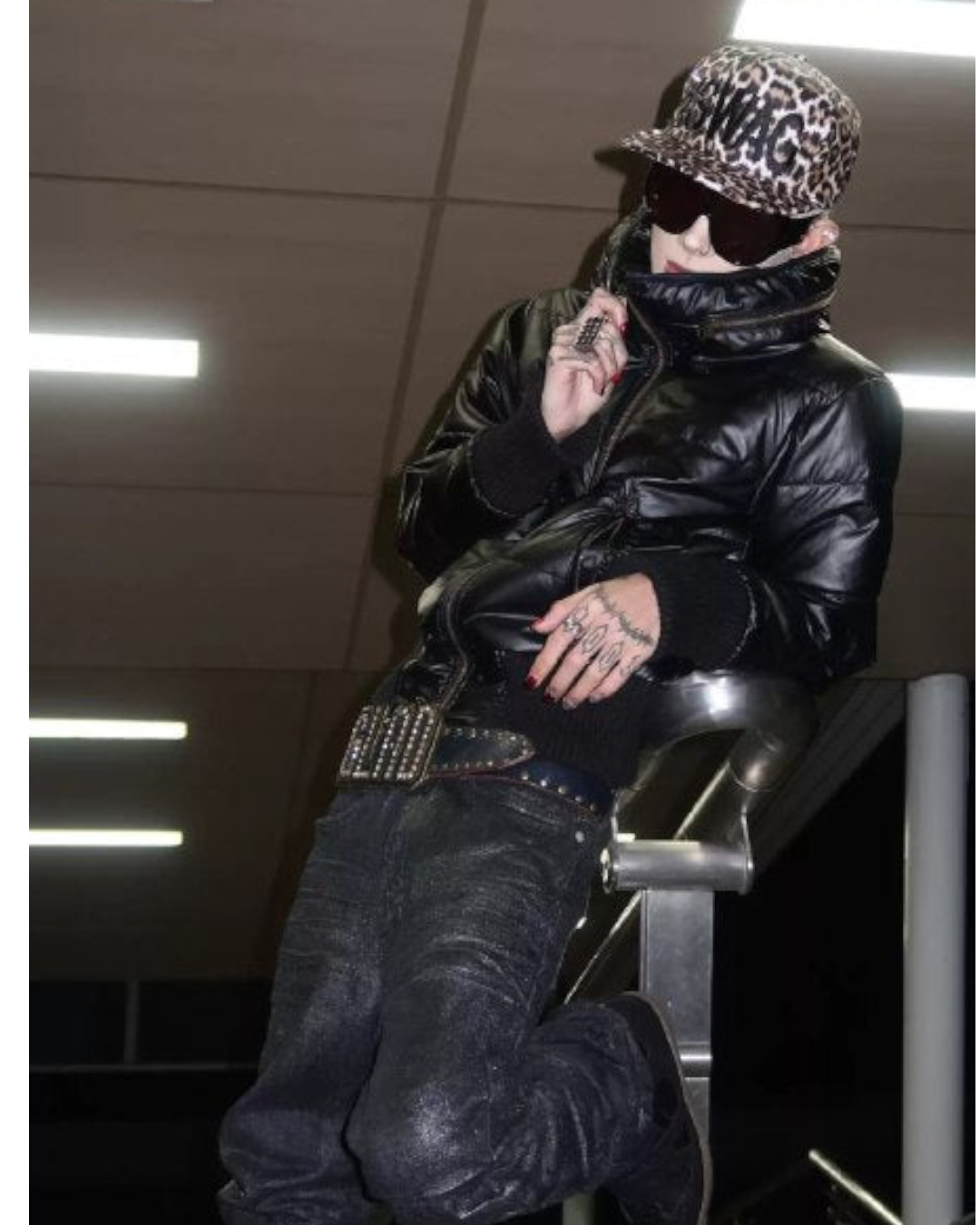 Leopard print cap with SWAG lettering, worn by a person in a black jacket