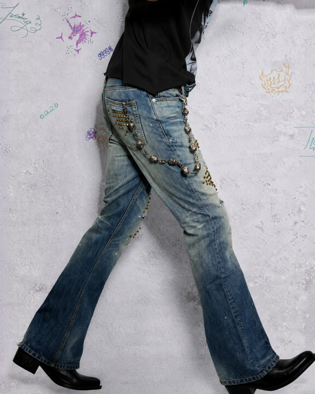 Light blue flare denim jeans with leopard-style stud patches and bead chain details
