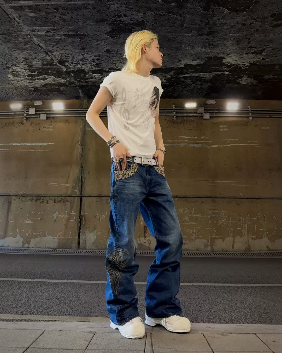 Dark blue flare denim jeans with large tribal embroidery on one thigh and hem