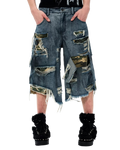 Distressed patchwork denim shorts with camo panels, frayed rips, and patch pockets