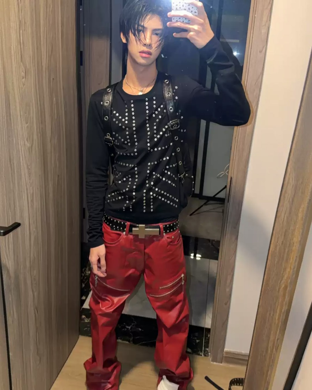 Black studded long-sleeve top with V-shaped dot pattern across the chest