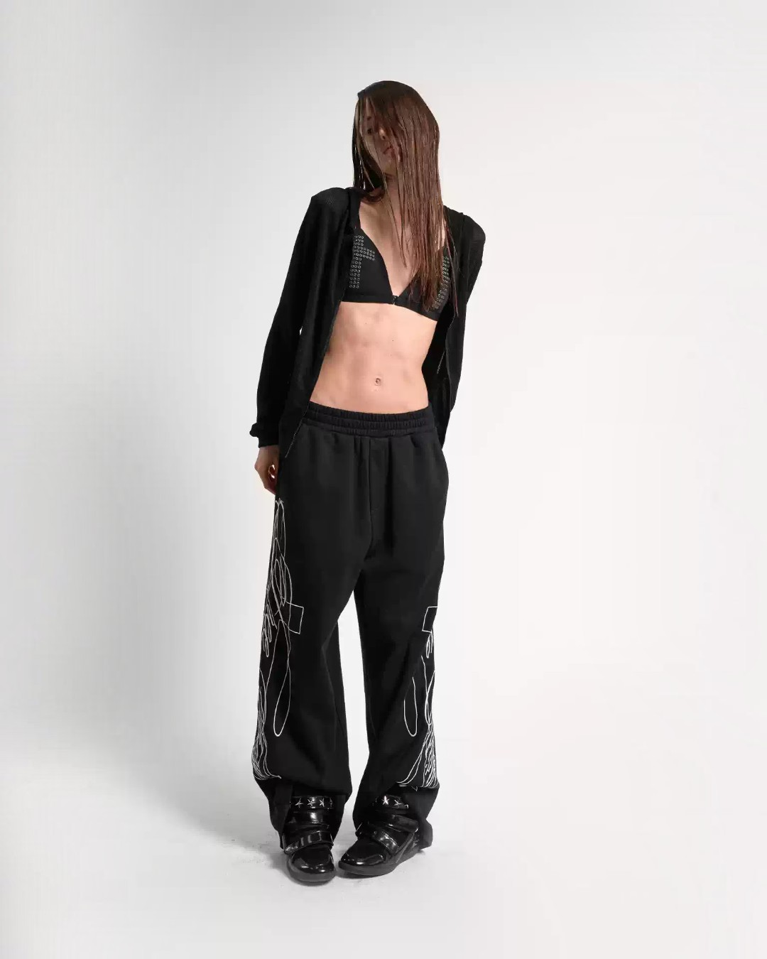 Black embroidered baggy sweatpants with graphic line embroidery, relaxed fit, cuffs