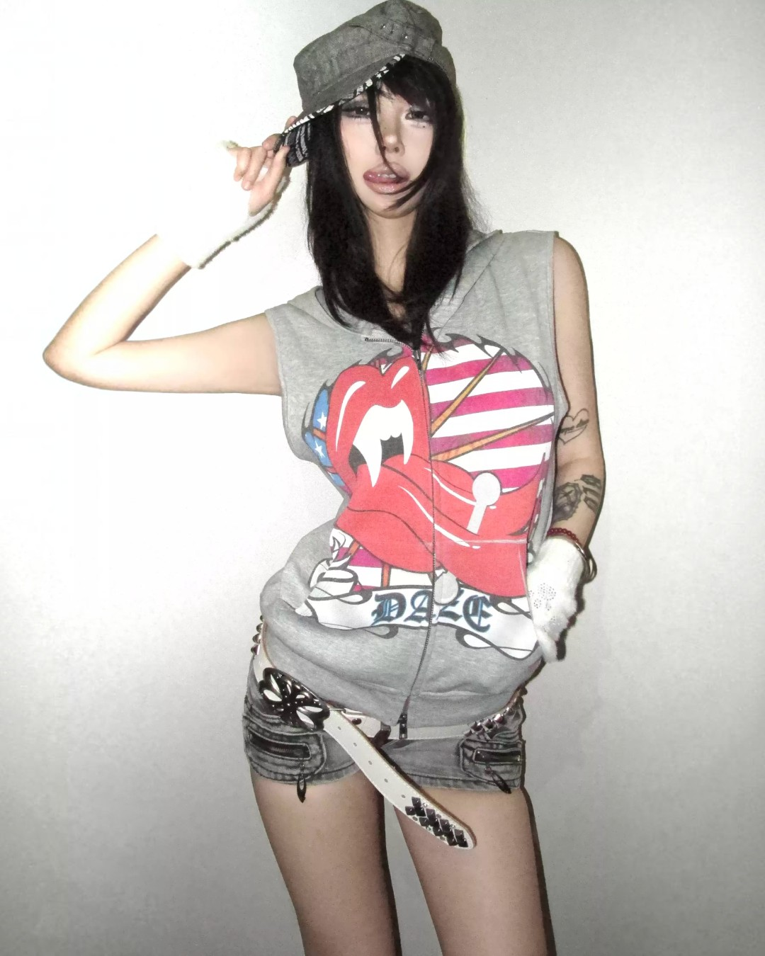 Person wearing a sleeveless graphic shirt with a heart design on a plain background