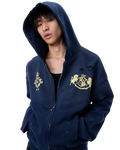 Navy hooded zip-up hoodie with gold crest patches and small sleeve distress holes