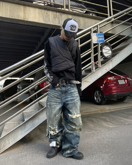 Relaxed medium blue denim jeans with large distressed patches at knees and thighs