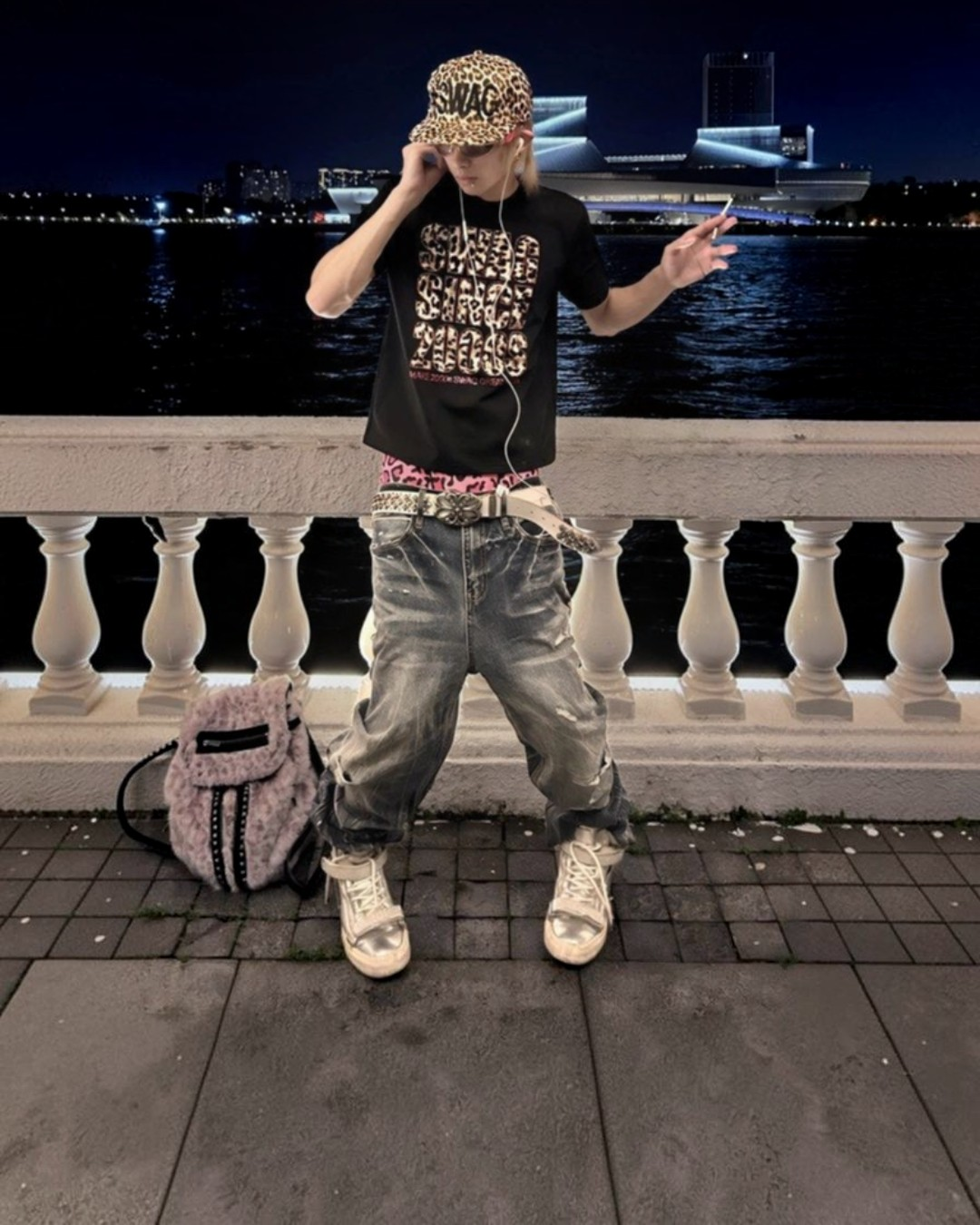 Light-wash baggy jeans on model, cuffed hem and distressed patches on legs