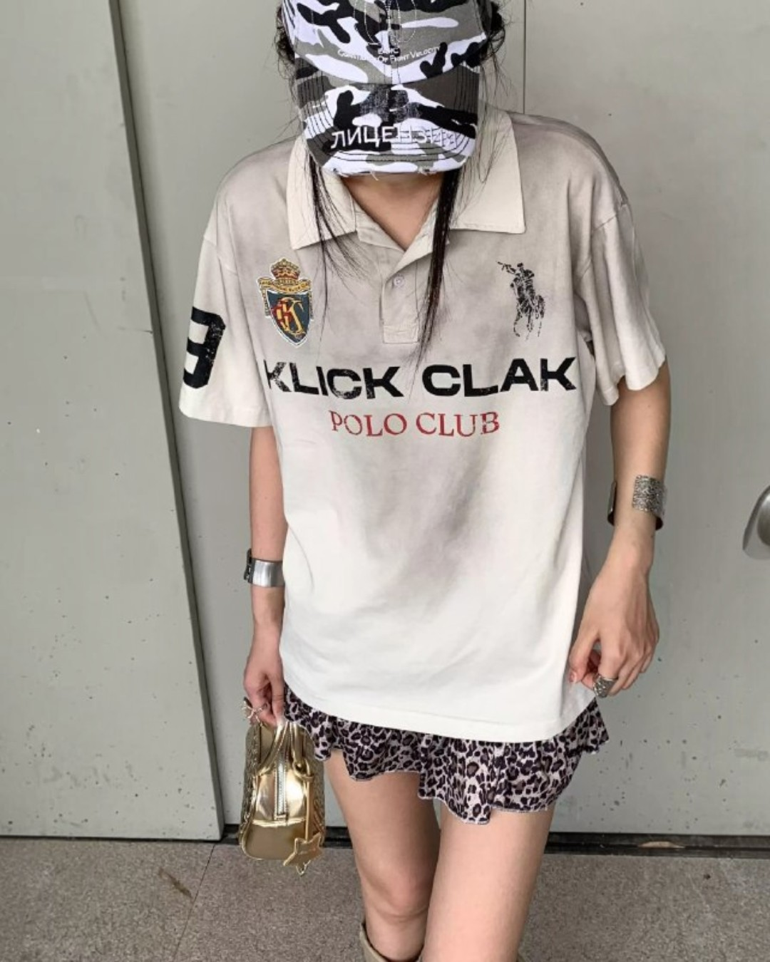 Distressed white polo tee with collar and short sleeves, front logo print