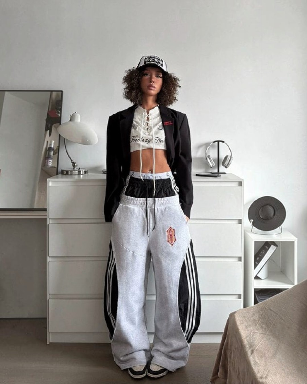 Gray track pants with side stripe panels and red crest patch, wide leg and elastic waist
