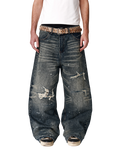 Baggy dark blue denim jeans with patched rips and worn knees, belt loops