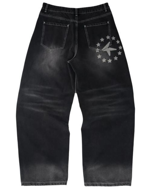 Black distressed jeans with a star and moon design on a white background